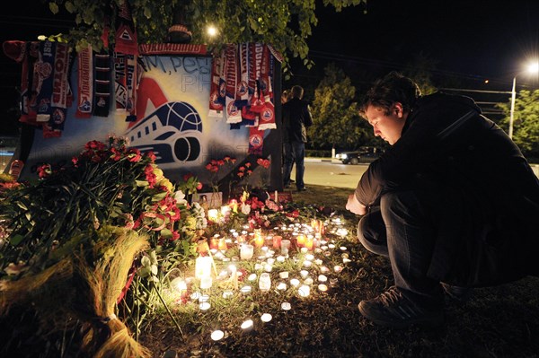 Yaroslavl, russia, september 8, 2011, lokomotiv yaroslavl fans commemorate players of a khl ice hockey team lokomotiv who died in a yak-42 passenger plane crash on september 7 by laying flowers and lighting candles at the arena-2000 stadium.