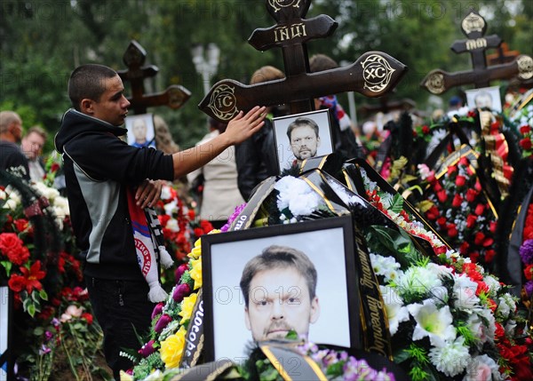 Yaroslavl, russia, september 10, 2011, relatives and fans grieve during the funeral of 14 hc lokomotiv yaroslavl players at leontyevskoye cemetery, a yakovlev yak 42 charter flight, which was to take lokomotiv yaroslavl hockey team to minsk, crashed on 7 september, shortly after the take off from yaroslavl's tunoshna airport, killing 43 out of the 45 people on board, 37 lokomotiv players died in the crash, one survived.