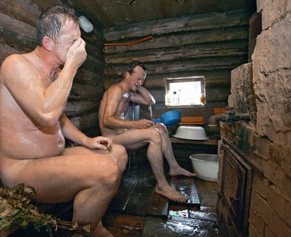 Two men in a traditional russian banya (sauna) built on the bank of the river mera in the ivanovo region of russia, august 2005.