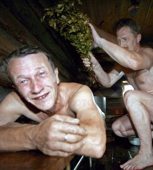 Two men in a traditional russian banya (sauna) built on the bank of the river mera in the ivanovo region of russia, august 2005.