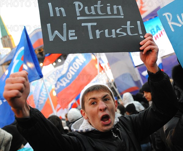 Moscow, russia, december 12, 2011, a young demonstrator holds up a sign reading in putin we trust during a rally staged by pro-kremlin youth groups in central moscow, the event took place two days after a mass protest against alleged vote rigging in the 4 december parliamentary election.