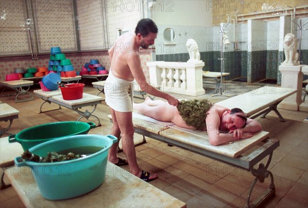 A man being rubbed with a birch branch in one of the halls of sanduovskiye bathhouse, popularly known as sanduny, the bathhouse is 105 today, it was named after a known russian actor sila nikolayevich sandunov and was made famous by its visitors actors, writers, public figures, moscow, russia, february 13, 2001.