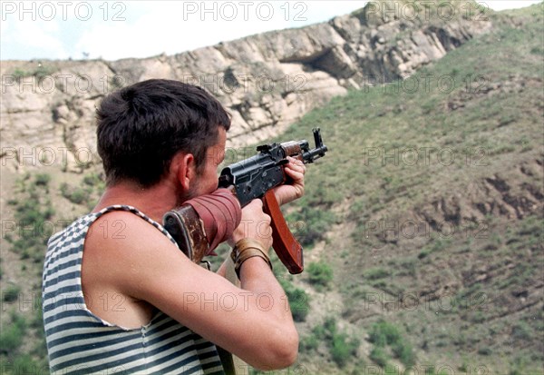 Makhachkala, daghestan, russia, august 12, a daghestani militiaman watch the mountains in the tsumadinsky district,from where chechen gunmen may appear ,the chechen militants who suffered considerable losses of personnel and equipment, are withdrawing from the tsumadinsky district, leaving behind small groups on roads and pathway, in order to slow down the advance of federal troops and aid the arrival of their reserves from chechnya.