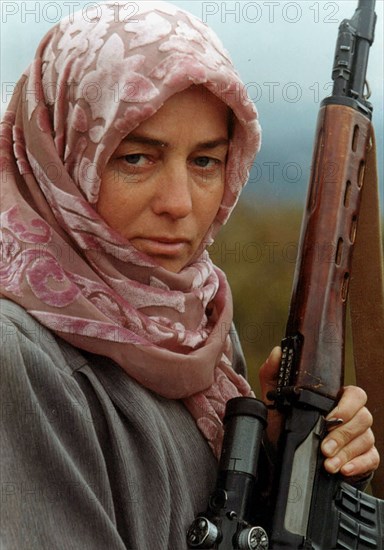 Dagestan, russia, october 22, 1999, director of the dylymsky women's medrese fazilyat kinailat magomedova poses to the camera with a sniper rifle in her arms, following the intrusion of the chechen gangs who plundered dagestani villages, kinailat magomedova and 14 more women were trained in practical shooting at the kazbekovsky regional military registration and enlistment office, kinailat wants to form a dagestani women's battalion that will fight against the bandits.