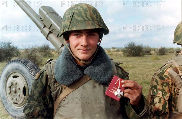 Chechnya, russia, october 27, 1999, gun layer, jr, sgt, yevgeny frankiv pictured showing the order of courage he was awarded with by commander of the eastern grouping of the russian federal armed forces lt,-general gennady troshev directly at the firing position in gudermes (eastern chechnya),on tuesday,he was awarded for bravery in combat actions for liberation of botlikh district of dagestan from chechen militants.