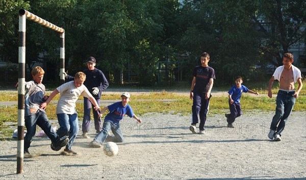 Teenagers play football in a chelyabinsk yard, russia, august 2006.