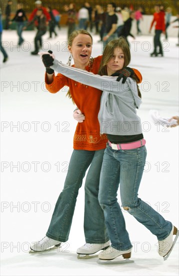 Teenagers skate on the ice rink in krylatskoye ice palace, moscow, russia, january 2007.