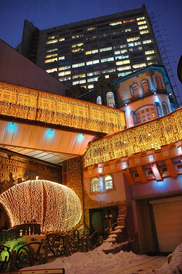 A restaurant in arbat street is illuminated at night, moscow, russia, march 2007.