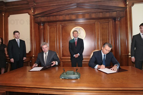 Moscow, russia, may 25, 2007, president of oil and gas company lukoil vagit alekperov and gazpromneft president alexander dyukov, l-r, foreground, sign a memorandum of understanding setting up a joint venture to handle oil recovery and refining, pictured in the background, centre, is gazprom chairman alexei miller.