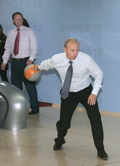 First deputy prime minister sergei ivanov (background) looks on as russian president vladimir putin bowls at the new sports complex ocean, vilyuchinsk, kamchatka, russia, september 5, 2007.