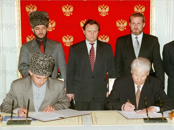A treaty on peace and principles of mutual relations between the russian federation and the chechen republic of ichkeria has been signed today, on may 12, 1997 by president boris yeltsin and chechen leader aslan maskhadov /left/, the picture shows the signing ceremony, in centre is russian security secretary ivan rybkin, chechen vice-premier movladi udugov /left, standing/ and chechen president's aide for national security akhmed zakayev /right, standing.