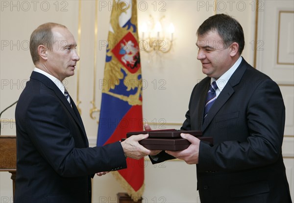 President of russia vladimir putin (l) hands over the awards, posthumously conferred on the soviet spy george koval, to defence minister anatoly serdyukov to be stored at the museum of russia's main intelligence directorate, or gru, during a ceremony in novo-ogaryovo residence, moscow, russia, november 2, 2007.