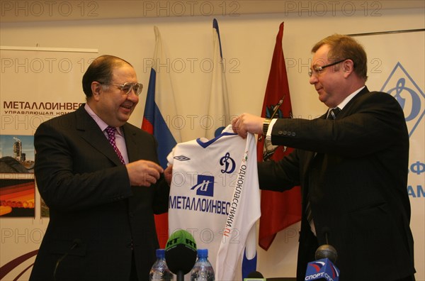 Moscow, russia, february27, 2008, russian billionaire alisher usmanov (l) who who controlls metalloinvest industrial holding company, and head of the russian audit chamber, sergei stepashin, pose with a jersey at a press conference about metalloinvest's new shirt sponsorship deal with dynamo f,c.