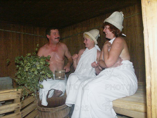A man and two women in a sauna (banya) of the sanatorium 'slavino', one of the best of its kind in the area, the sanatorium was built by west-siberian steel works for those employed by the enterprises of the region, kemerovo region of russia, 2003.