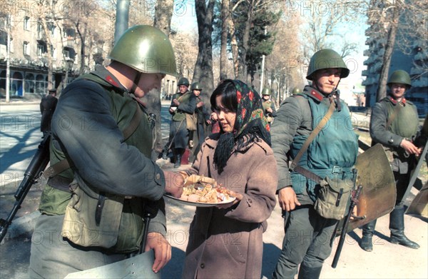 A woman offers a treat to soldiers in dushanbe, a state of emergency was declared in dushanbe after a violent unauthorized rally, policemen and servicemen were deployed to keep order, tajikistan, february 1990.