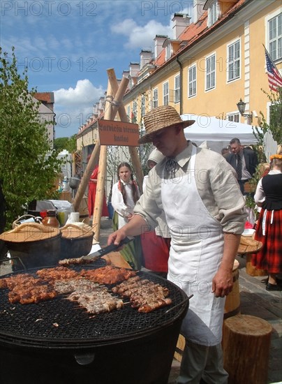 Shashliks of chicken-meat and pork are roasted on the grates of cast-iron pans, different types of smoke products cooked on cast-iron pans are national meals of latvia, folk festival, riga, latvia, 2003  .
