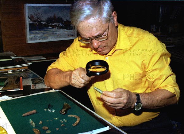 Alexander avdonin, organiser of excavations of the last russian tsar's remains, examine beads, catridge-cases, pistol bullets, hooks, buttons, a fragment of a golden bracelet that he relates to remains of maria and alexy, children of nicholas ll , yekaterinburg, russia, october 21, 1998.