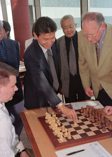 Elista (kalmykia), chess city, russia, september 30 ,1998, president kirsan ilyumzhinov (c) of kalmykia (a republic in the south of russia) who heads the international chess federation and referee gert geissen from holland (r) pictured symbolically starting the games of the 33 world chess olympiade in elista,the capital of kalmykia,on tuesday,the chess competition takes place in a specially built chess city with the participation of 110 men and 74 women teams from the whole world.