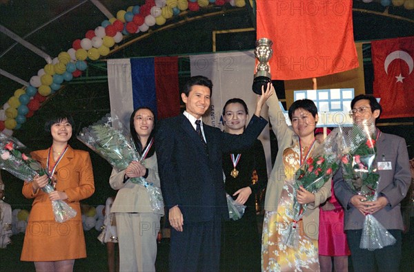 Elista, chess city, kalmykia, october 13, 1998, sportswomen of the chinese national chess team demonstrate the olympic cup, handed to them by the fide president kirsan ilyumzhinov /centre/, in elista, the capital of russia's republic of kalmykia, where the 33rd world chess olympiad finished on monday, october 12, the russian national women's team won the second place, the russian men's team won the gold medals for the fourth time, and their main rival team of the u,s,, got the silver.