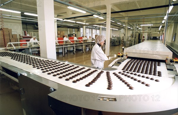 Laima chocolate shop: automatic production line for chocolate coated marshmallow at the 'laima' confectionary factory in riga, latvia, 2003.