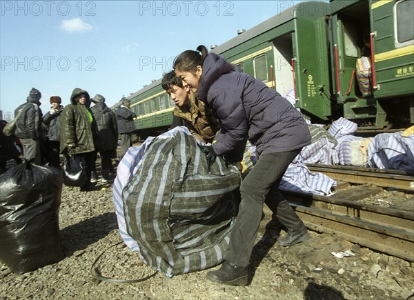 Chinese vendors disembarking a train in grodekovo with their wares, brought here to be sold in russia, maritime territory, russia, february 27 2003, the special train shuttles between chinese suifenhe city and russian grodekovo, -sayapin vladimir- .