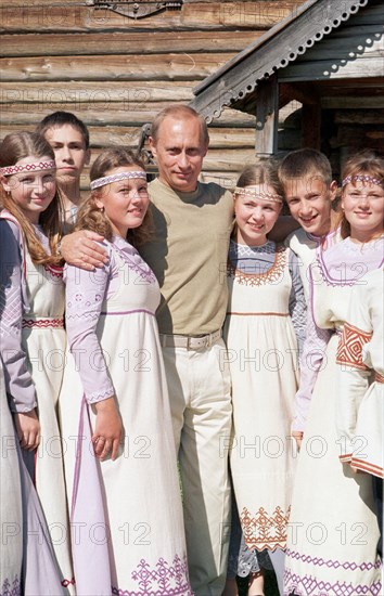Karelia, russia, august 21 2001, president vladimir putin, on vacation here, pictured among the participants of a folklore group, on the famous island of kizhi in the onega lake, at the outdoor museum of wooden architecture, sergei velichkin  21,08,2001.