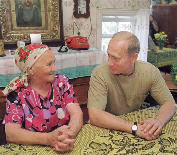 Petrozavodsk, karelia, russia, august 19 2001, president vladimir putin who spends his vacation in karelia pictured talking with maria stepanova in the village of yamki,on saturday , he saw the interior of a traditional karelian home, maria stepanova is a former workers of the kizhi outdoor museum of wooden architecture.