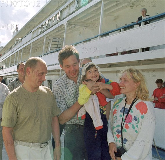 Petrozavodsk, karelia, russia, august 19 2001, president vladimir putin who spends part of his vacation in karelia visited the famous island of kizhi in the onega lake on saturday, picture shows vladimir putin (l) talking with a family of tourists who came by a motorship to kizhi island famous for its outdoor museum of wooden architecture   19,08,2001.