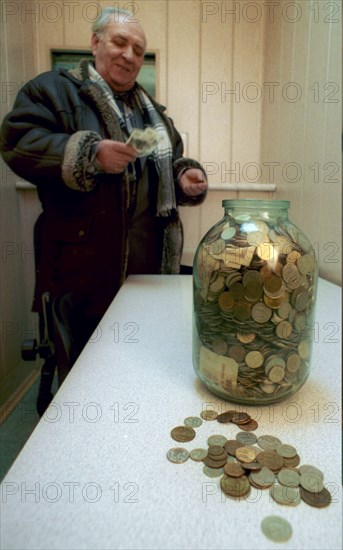 Omsk, russia, 2/02, glass jars filled with banknotes of 1993-1995 and coins of 1961-1996 are brought by residents of this siberian city to saving banks to change them for the present-day currency, one rouble is given for one thousand of old roubles, the currency exchange will continue till january 1, 2003.