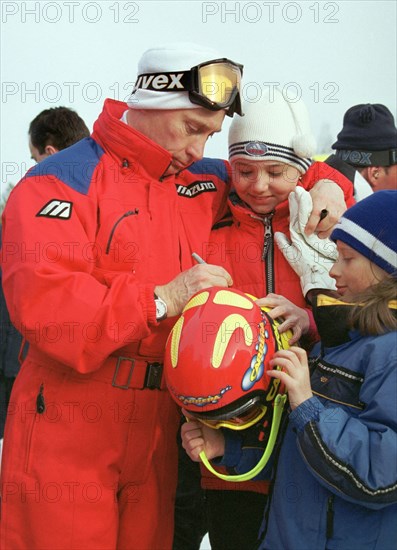 Irkutsk region, russia, march 27 2002, president vladimir putin giving autographs to little skiers while spending his brief vacation at the baikalskaya ski base in irkutsk region.