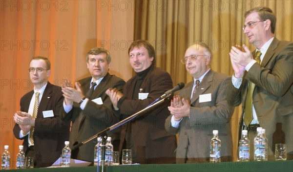 Moscow, russia, march 30, 2002: participant in the all-russian political movement 'liberal russia' (l to r): pavel arsenyev, co-chairman of the movement sergei yushenkov, chairman of the executive committee of the movement vladimir golovlyov (golovlev) and co-chairmen boris zolotukhin and viktor pokhmelkin applauding after the announcement of the movement's transformation into a political party, at the 3rd extraordinary congress of the movement, on saturday.