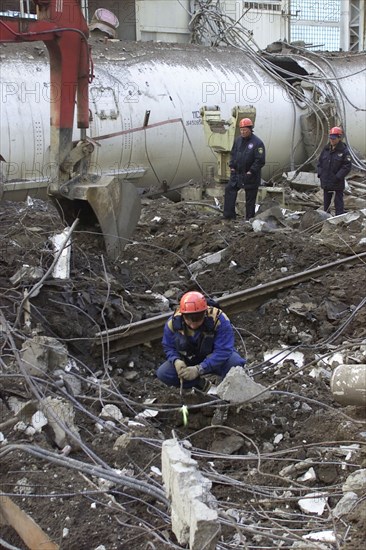 Baikonur, kazakhstan, may 14 2002: workers clearing the fragments of 'energia' rocket carrier and first russian space shuttle 'buran' from debris of the destroyed roof of the assembly and test block where it was stored before the accident , rescuers found seven victims of the tragedy.