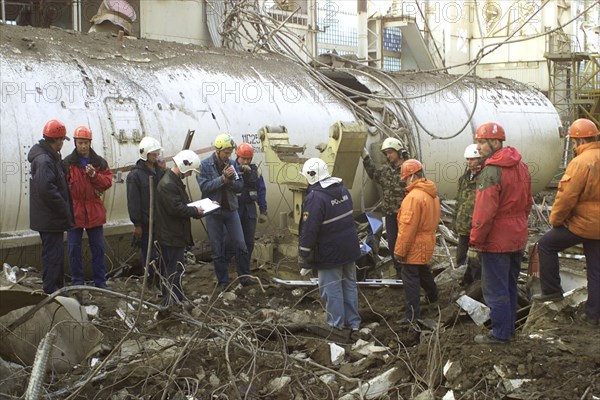 baikonur, kazakhstan: may 14 2002: workers clearing the fragments of 'energia' rocket carrier and first russian space shuttle 'buran' from debris of the destroyed roof of the assembly and test block where it was stored before the accident , rescuers found seven victims of the tragedy.