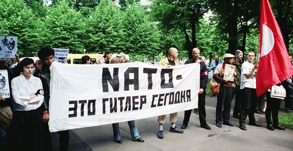 Riga, latvia, june 17, 2002: the protestors hold a banner reading 'nato is the hitler of our time', an authorized picket of latvian national bolsheviks protesting against latvia's joining nato, was held at the building of the latvian government, the protestors demanded a referendum on joining nato to be held in latvia.