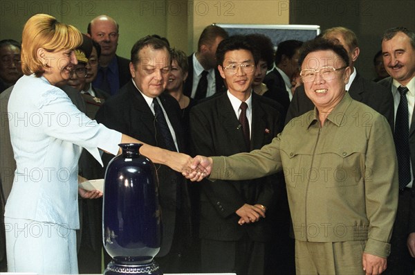 Visiting north korean leader kim jong-il (r) shakes hands with director of the trade complex 'ignat' yelena kalinina (l) at the complex in vladivostok on friday, the honourable gueat presented a traditional korean vase (foreground) to the administration of 'ignat,' 8/23/02.