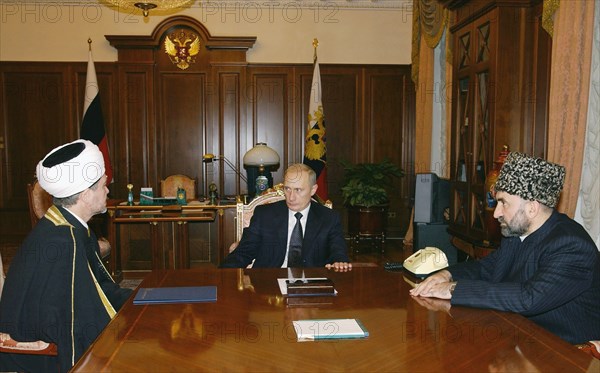 Moscow, russia, october 24 2002: russian president vladimir putin (c) pictured during the meeting with the chairman of the muftis council of the muslim board for european russia ravil gainutdin (l) and head of the north caucasus muslims coordinating center, mufti magomed albogachiyev, who also holds the office of the ingush republic muslim board chairman,russian president thanked the muslim clergy for their civic position in the struggle against terrorism.