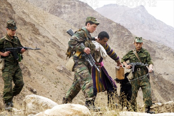 Tajikistan , november 13 2002: russian border guards on the tajik - afghan frontier pictured capturing of a trespasser (a resident of a tajik village localed near the border), the local population often try to smuggle gasoline and implements to afganistan for selling.