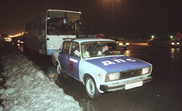 Moscow, russia, november 15 2002: tajik illegal immigrants in a bus escorted by a police car (in pic) on their way to chkalovsky airport for further deportation, the people's courts of khimki and podolsk districts took the decisions on the deportation of a group of tajik immigrants staying in moscow region without valid documents.