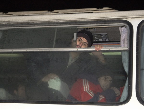 Moscow, russia, november 15 2002: tajik illegal immigrants (in pic) in a bus prior to their departure for chkalovsky airport for further deportation, the people's courts of khimki and podolsk districts took the decisions on the deportation of a group of tajik immigrants staying in moscow region without valid documents.