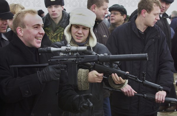 Moscow region, russia, november 15 2002: visitors to the exhibition familiarizing themselves with new samples of modern small arms of foreign and home production at a shooting ground in balashikha near moscow, on friday, the demonstration was held by servicemen of russian ministry's special task force within the framework of the 6th international state security forum interpolitex - 2002, (photo alexander yakovlev).