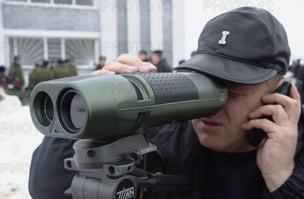 Moscow region, russia, november 15 2002: a visitor to the exhibition trying a piece of equipment for detecting optical devices in use, the demonstration was held on friday within the framework of the 6th international state security forum interpolitex - 2002, (photo alexander yakovlev).