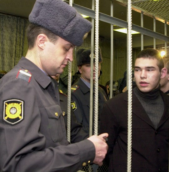 Moscow, russia, november 20 2002: one of the accused (right) under guard of policemen at the moscow city court, where verdicts were handed down today, wednesday, to five persons charged with participating in teenage violence on tsaritsino market in southern moscow on october 30, 2001, (photo oleg buldakov) .