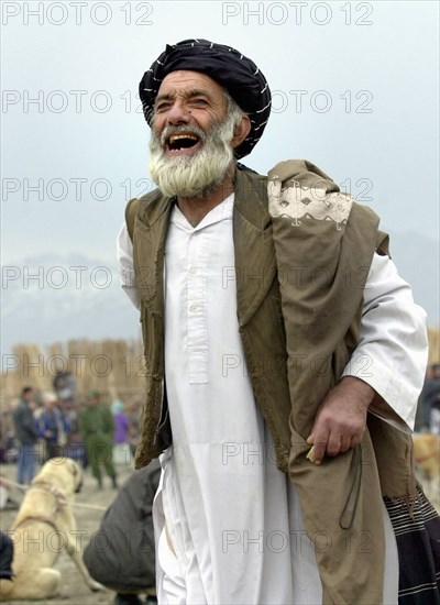 Kabul, afghanistan, march 9 2003 a fan shouts when watching dog fights that remain one of the chief attractions in kabul, the fights draw thousands of spectators, in case it wins, an asian sheepdog may bring solid money to its owner and the fans who have bet on it.