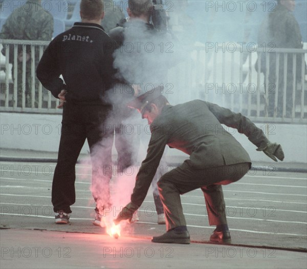 Moscow, russia, april 20, 2003, a firefighter putting out a smoke candle during a russian championship's soccer match cska (moscow) vs rostov (rostov-on-don), on saturday, rosrov won 1:0.