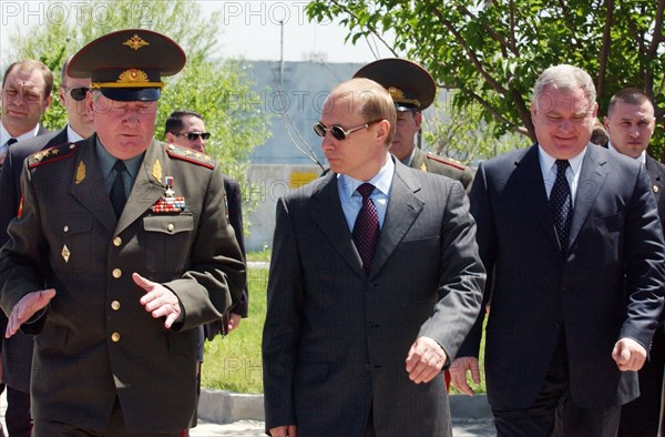 President vladimir putin (c), accompanied by commander of the volga-urals military district colonel-general alexander baranov (l), visiting the 201st russian motorized division, stationed in tajikistan, on sunday april 27, 2003.