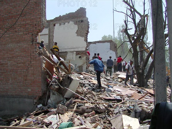 Chechnya, russia, may 12, 2003, people pictured clearing the debris in the village of znamenskoye where a powerful explosion ruined the buildings that housed the district administration ,on monday , many people were killed and injured in the terrorist act.