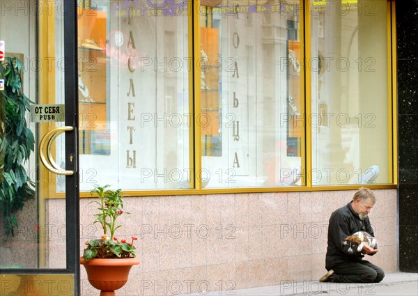 A homeless man begs outside an exclusive store in moscow, russia, 2003.