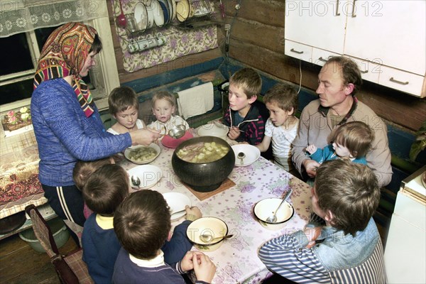 Chuvashia, siberia, russia, october 25 2003, chuvash family living in poverty, mother valentina pours soup for father leonid and their children, there are ten boys in the family, the eldest is 13 years old and the youngest is only three weeks old.