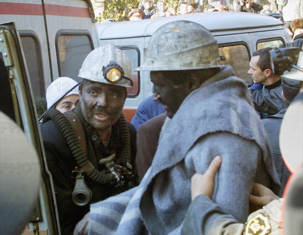 Rostov region, russia, october 29, 2003, one of the miners (r) found in the blocked mine today and a rescue worker (l), eleven miners out of 13 who spent 6 days in the blocked 'zapadnaya' mine were saved today, one of them died in the mine and one more is still missing, the search goes on.