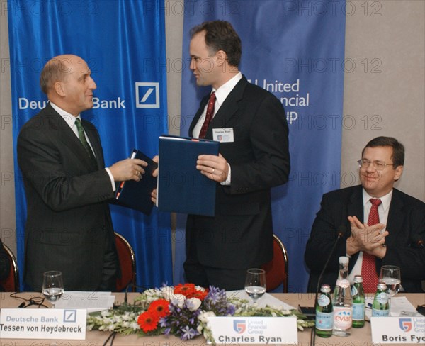 Tessen von heydebreck (deutsch bank ag) (l) and charles rhine (united financial group) exchanging documents during signing buisness cooperation agreement in hotel 'balchug-kempinsky' on thursday,  boris fyodorov (russia) (r) represented united financial group, 11,2003, moscow .